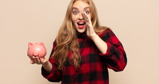 blonde frau mit sparschwein