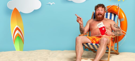 topless bearded redhead man posing on beach